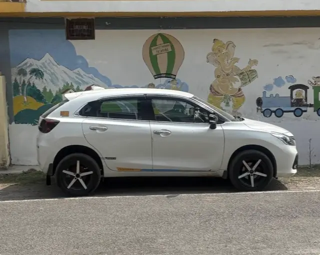 White taxi parked outside a building, side view